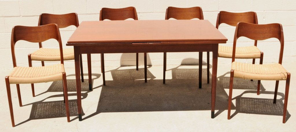 7 PC. DANISH MODERN DINING ROOM SET. CONSISTING OF A : 7 PC. DANISH MODERN DINING ROOM SET. CONSISTING OF A TABLE AND SIX SIDE CHAIRS WITH RUSH SEATS. TABLE HAS PULL OUT SIDES FOR EXTENSION. STAMPED MADE IN DENMARK. EXTENSION LEAVES OUT 93" W. GOOD. T 29"