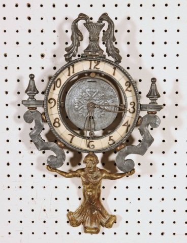 METAL WALL CLOCK. FIGURE OF A MAN SUPPORTING THE: METAL WALL CLOCK. FIGURE OF A MAN SUPPORTING THE CLOCK. URN DECORATION AT THE TOP. CLOCK NOT WORKING. 18" H X 11 1/4" W.
