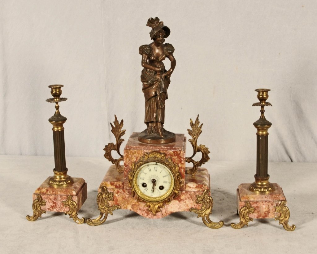 3 PC. FRENCH SPELTER & MARBLE CLOCK SET. FIGURE OF A: 3 PC. FRENCH SPELTER & MARBLE CLOCK SET. FIGURE OF A WOMAN ON THE CLOCK. PR. REEDED COLUMN CANDLESTICKS. 12 1/2" H X 5 3/4" W. CLOCK NOT WORKING. CL 18 3/4" H X 12 1/2" W.