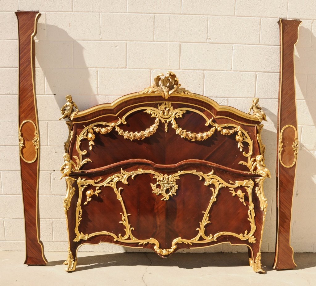 ANTIQUE FRENCH LOUIS XV STYLE MAHOGANY BED. DORE BRONZE: ANTIQUE FRENCH LOUIS XV STYLE MAHOGANY BED. DORE BRONZE MOUNTS. FIGURES OF CHERUBS ON THE TOP AT THE ENDS AND AT THE BOTTOM ON THE ENDS. FLORAL SWAGS AND SCROLLED BRONZE MOUNTS ON THE HEADBOARD & FOOT