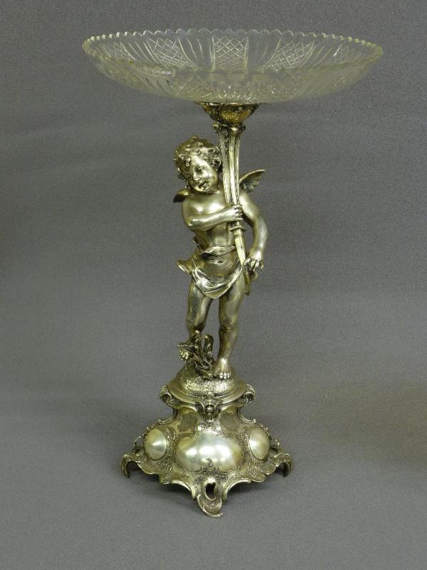 Circa 1900 Silver Plate Putti holding a cornucopia,: Circa 1900 Silver Plate Putti holding a cornucopia, fitted with a diamond-and-fan cut glass dish and raised on a rococo pedestal. h. 22-3/4", dia. 13-3/4". Very good condition. Found in Waterloo Iowa 