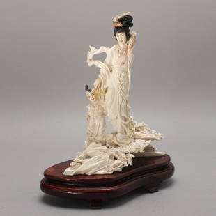 A CARVED & PAINTED IVORY FIGURAL GROUP, Hgt.10 1/2": A CARVED & PAINTED IVORY FIGURAL GROUP, Hgt.10 1/2"(26.6cm)depicting a celestial being with child upon jagged rockwork of lush flowering plants- First part of 20th Century