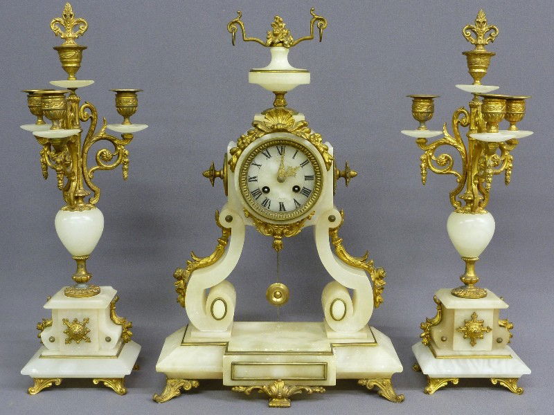 French alabaster garniture clock set, c. 1900, Sig: French alabaster garniture clock set, c. 1900, Signed LM, Paris in the Louis XV style with brass foliate décor, H 19.25", W 12", D 4.75" good condition--Wgt. 26lbs