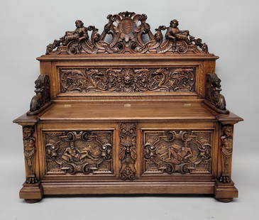 Circa 1880's Heavily Carved Horner Lift Seat Bench with Putti, Griffins, & Northwind Face. All: Circa 1880's Heavily Carved Horner Lift Seat Bench with Putti, Griffins, & Northwind Face. All executed in 1/4 cut oak.Fantastic bench. H 50" w 56" d 21.5". Good refinished condition. Found in