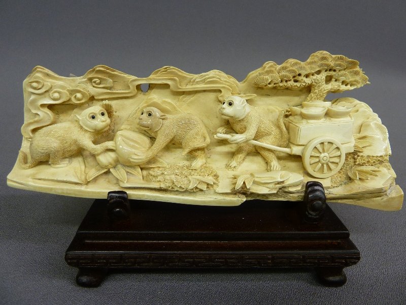 CHINESE QUALITY HAND CARVED IVORY TUSK of MONKEYS,: CHINESE QUALITY HAND CARVED IVORY TUSK of MONKEYS, H 4.5" on 1.25" stand, L 7.75" :Carving depicts 3 monkeys shown loading up a cart. Includes a wood stand.