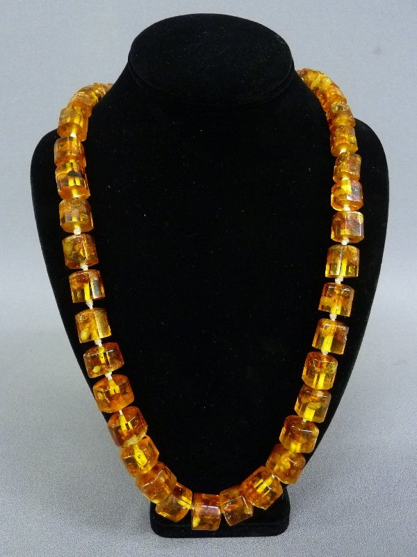 A Clear Golden Amber Necklace consisting of 48 var: A Clear Golden Amber Necklace consisting of 48 various sized beads on individually hand knotted string -overall length 29" - good condition