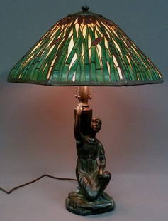 Signed Handel Cattail Overlay Lamp: Circa 1915 Signed Handel Cattail slag glass overlay lamp with Woman Carrying Urn Signed Handel base. Has 8 caramel color panels with green cattail leaves and burgundy tips. Height 26" diameter 18.5" -