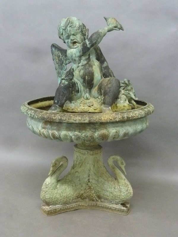 Solid Cast Bronze Fountain with Winged Cupid holding a: Solid Cast Bronze Fountain with Winged Cupid holding a sea shell with it's hand resting on a turtle with a frog sitting on it's leg. The whole fountain supported by 3 swans. Height 47" dia. 32" . Foun