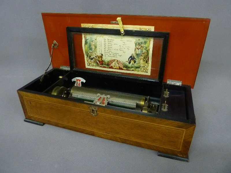 19th Century Swiss Cylinder Music Box that Plays 10: 19th Century Swiss Cylinder Music Box that Plays 10 Songs Listed on Song Sheet marked B.H.A. Ste Croix , Switzerland - width 24" depth 9.5" height 6" - good playing condition.