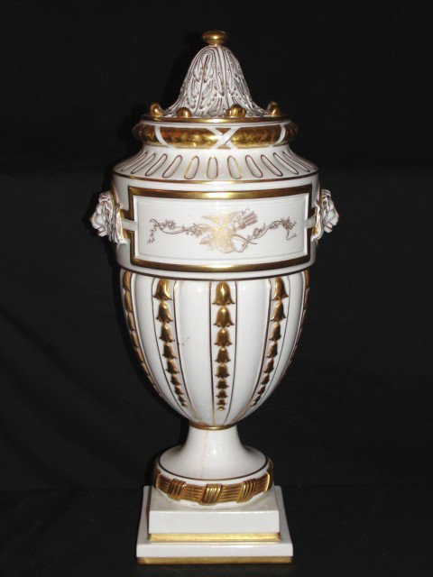 Portugal Porcelain Lidded Urn, With Lion Heads : Gilted decoration through out. ( See photo's ) Hair line crack on plinth base. H.17'' Diam. 7''.
