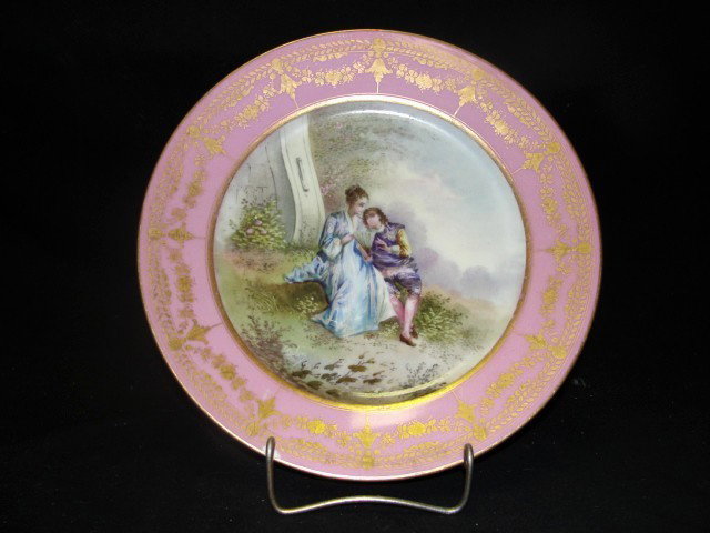 Sevres Hand Painted Plate With Romantic Scene: border in darker pink, decorated with raised gilt highlight. Sevres traditional mark on bottom. Condition chip on rim. 9 1/4'' Diam.