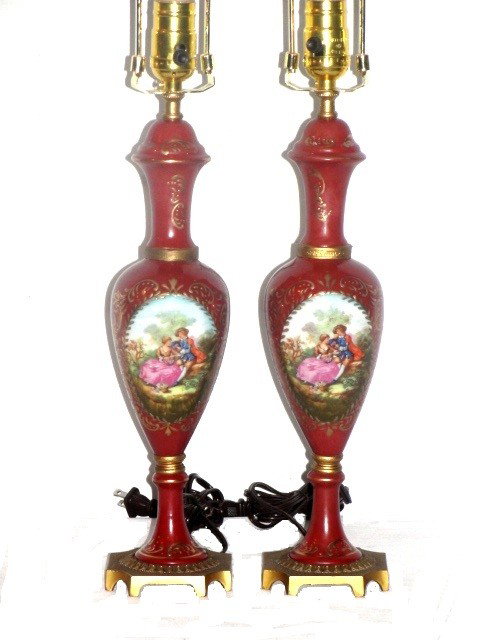 Pair French Style Sevres Table Lamps: In a brown tone background with scene of romantic lovers. Condition rings around middle top have been repaired. Possible one top has repair or from factory?. Showing dripping of paint on underside, re