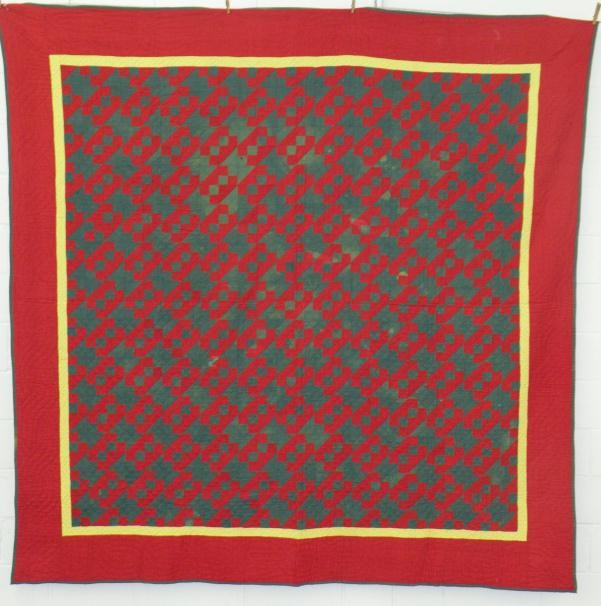 Red and green quilt: ca. 1860-1900, pieced block and triangle pattern quilt red, green & black triangles with yellow border, cotton front with printed cotton back, 93"x 91";