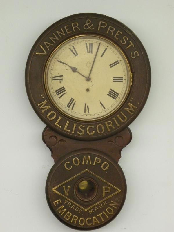 Advertising clock: ca. 1900, mfg. by The British United Clock Co., Birmingham, England, metal over wood case, advertising Vanner & Prest "Molliscorium Compo Embrocation", painted metal dial, 8 day spring driven time onl