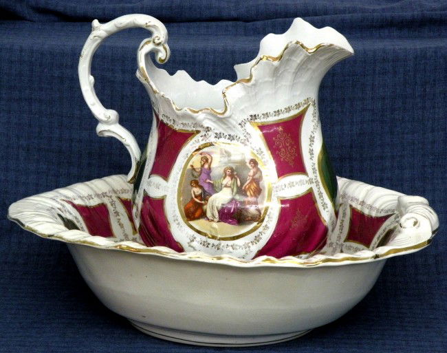 Earthenware wash bowl & pitcher: ca. 1900; shell molded form, whiteware glaze, polychromal transfer of 2 classical scenes on green & burgundy panels, gilt highlighting, marked E.P. & Co., bowl 17 ¼"d, 4 3/8"h; pitcher 6 ½"d, 11 ¾"