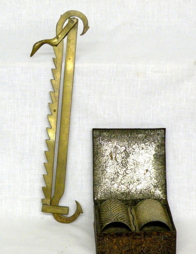 Brass lamp trammel & tole spice box: ca. 1850-1900; trammel with birds head detail, 13 ½"x 3 ¾"; pressed tin spice box with bread & nutmeg graters, stamped "Bryant & May, London", 4 ¾"x 4 ¾"x 2";