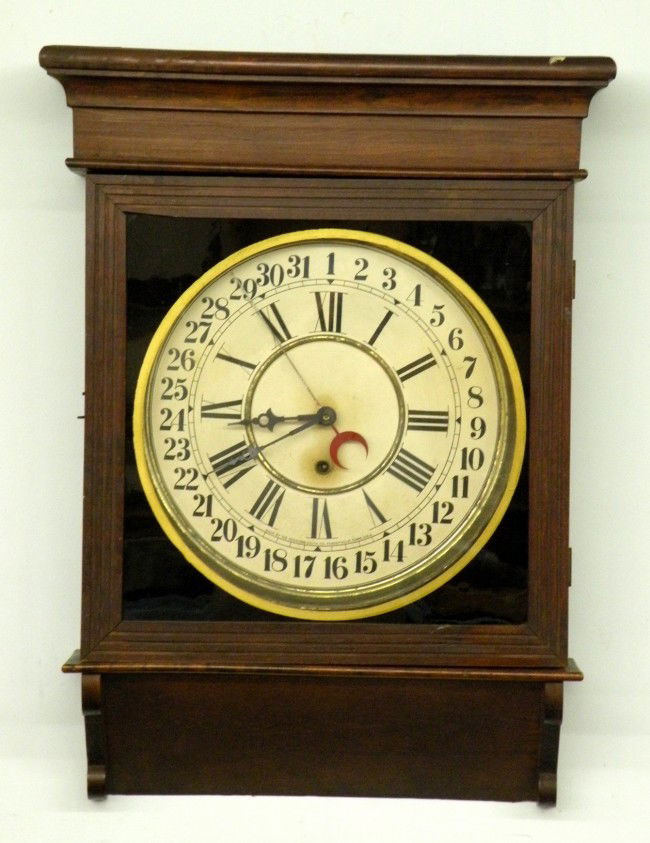 Sessions Clock Co. wall clock: ca. 1900; wall clock with an 8 day time and calendar, spring driven pendulum movement in a mahogany finished softwood case with label on reverse, 24"x 16 ½";