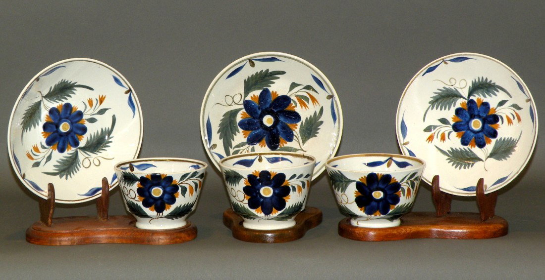 3 Leed's type floral cups & saucers: ca. 1830; pearlware with floral design in blue, brown, green, orange & yellow, cups 3 5/8"-3 7/8"d, 2 3/8"-2 5/8"h; saucers 5 ½"-5 ¾"d, 1 ¼"h;