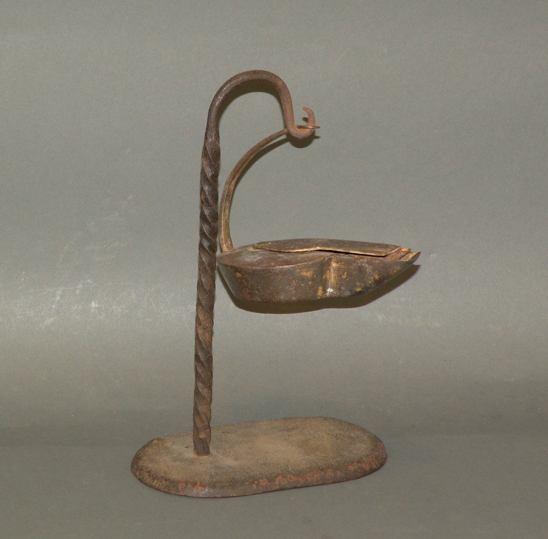 Wrought iron betty lamp & stand: ca. 1800-40; lamp with sliding cover, 5"x 3"x 4"; wrought iron stand with twisted shaft, 6"x 3 ½"x 9 ¾";