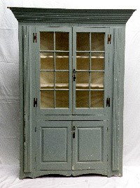 Federal one piece softwood corner cupboard: ca. 1800-30; a molded cornice above two glazed eight-light upper doors and two single panel lower doors flanked by fluted pilasters, gouge & chip carved frieze & base, interior painted date of 1826, 5