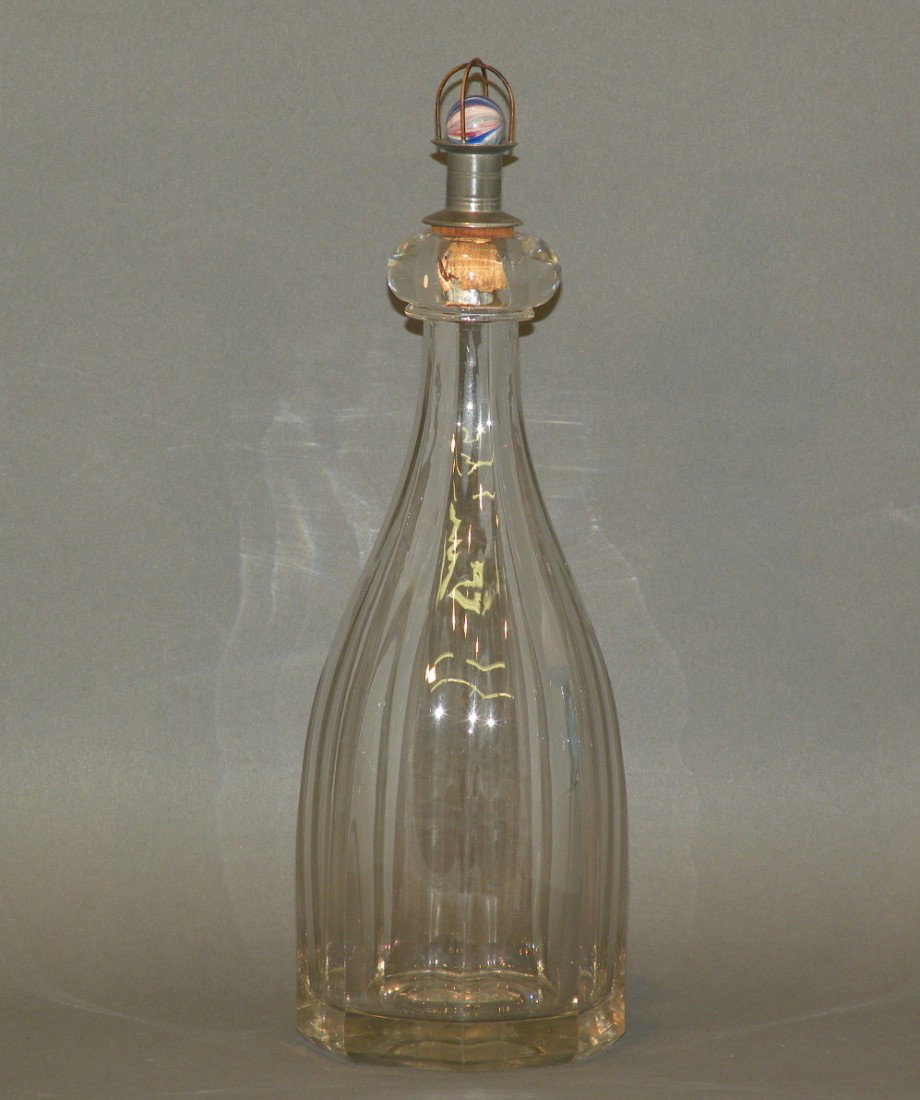 Flint glass bar bitters bottle: ca. 1860; eight colorless panels with onion skin glass marble top cork and pewter stopper (J.B. Williams), 3 ½"d, 11"h;