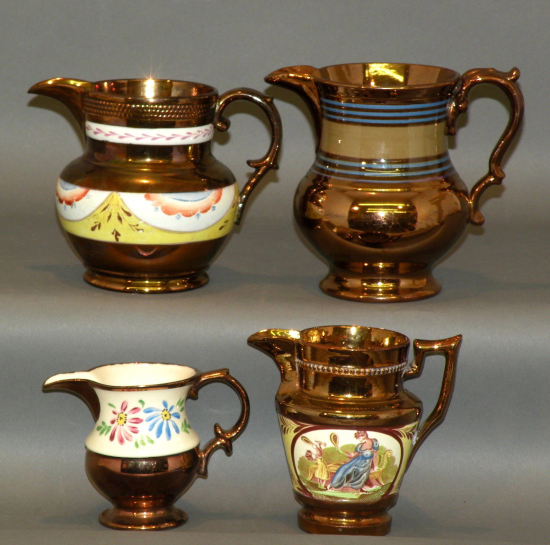 4 copper lustre creamers: ca. 1830-80; olive band bracketed by two sets of three narrow blue and brown bands, 4 3/8"d, 5 ½"h; small pitcher with pink luster wreath on white band and blue, brown, red and white swags on yellow 