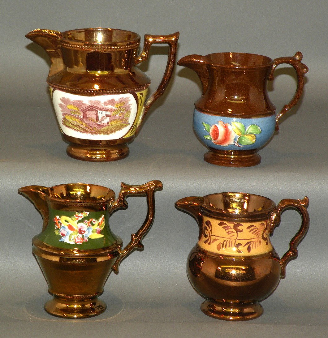 4 copper lustre creamers: ca. 1830; beaded rings and polychromal transfer of building on yellow band, 3 7/8"d, 5"h; raised rose and leaves design in brown, green and red on blue band, 3 ¼"d, 4 ¼"h; raised floral design in bl