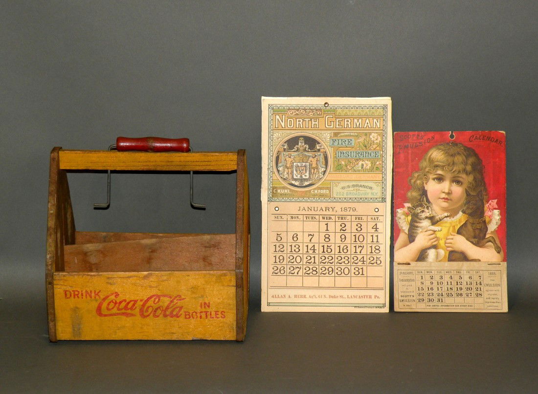 2 advertising calendars & Coca-Cola carrier: ca. 1879-1930; "Scotts Emulsion" with little girl, dog and cat, 8 ½"h; "North German Fire Insurance", 7 ½"; wooden yellow six bottle Coca-Cola carrier, 8";