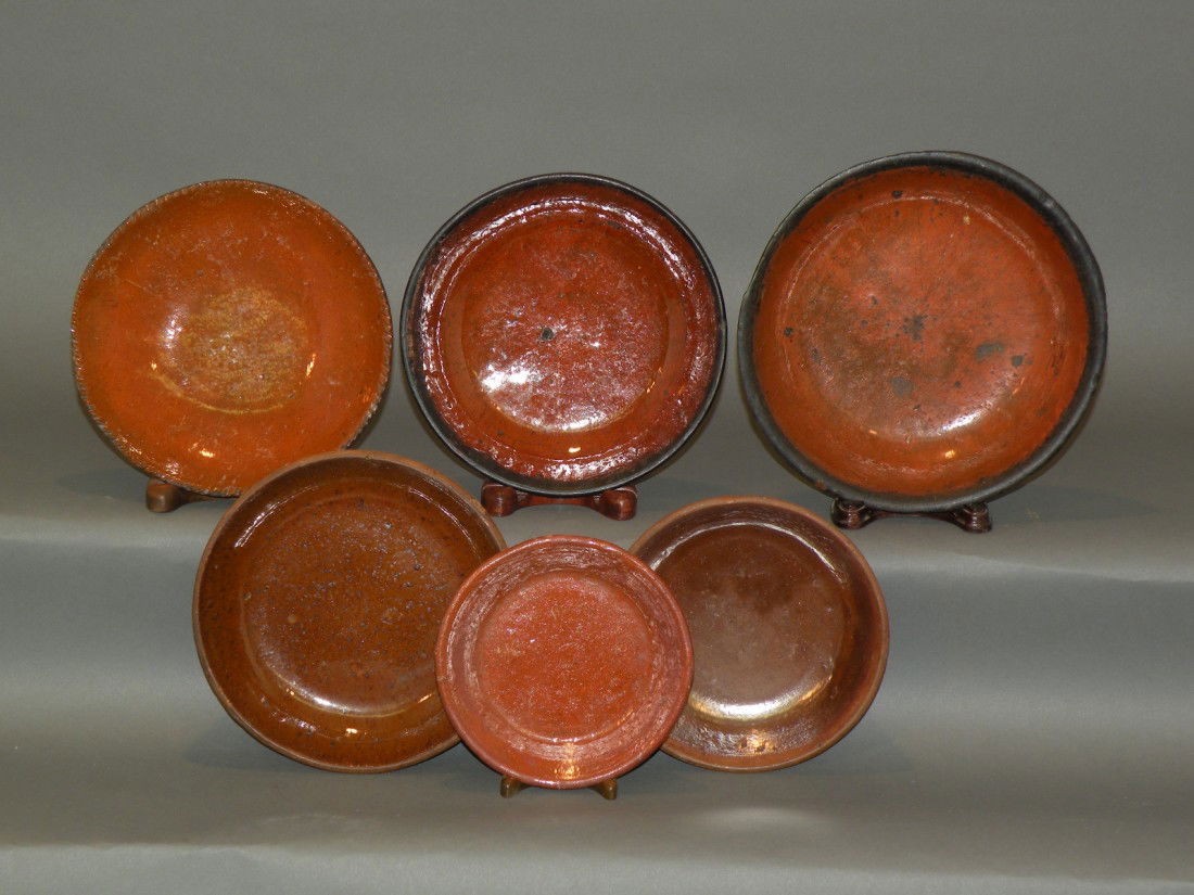 6 PA redware pie plates: ca. 1870-1920; lead glazed with coggled rim, 6 ¾"d; Medinger type with manganese speckled lead glaze, 6 7/8"d; brown lead glazed, 6 1/8"d; late redware with orange brown lead glaze, 5 ¼"d; two in or