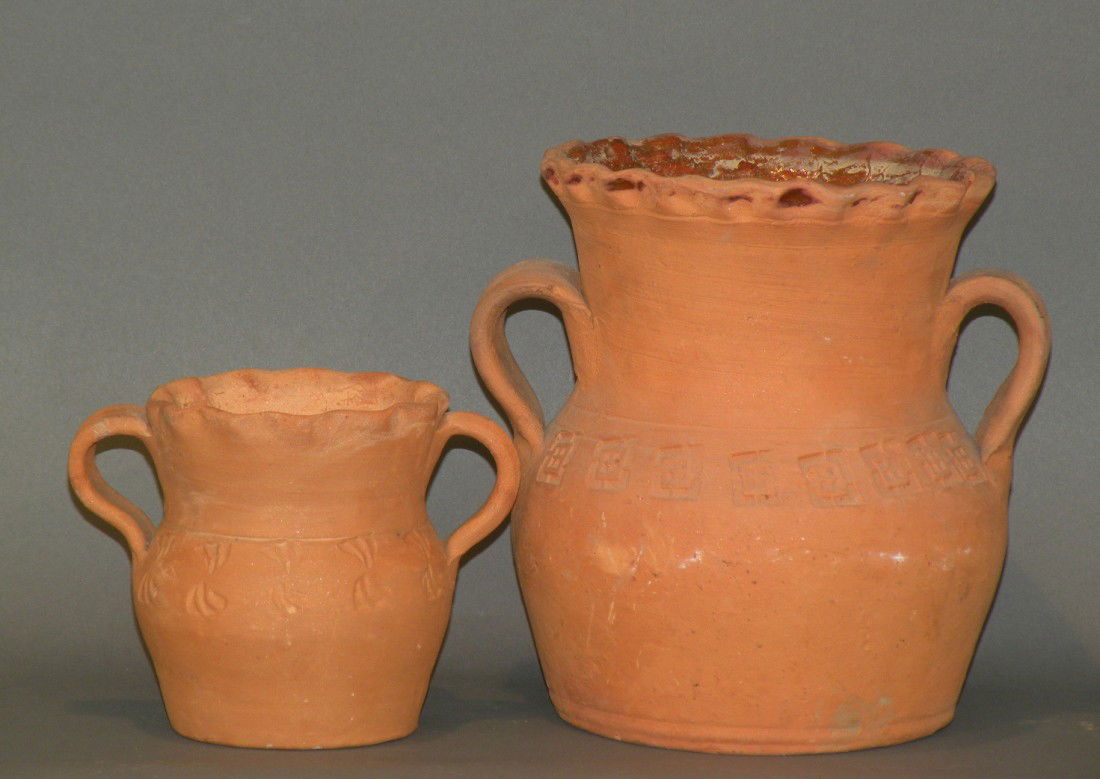 2 Schofield redware vases: ca. 1940-60; with interior lead glaze only, strap handles, piecrust type rim and impressed window lattice designs on shoulder, 6 ½"d, 7 3/8"h; with impressed curved double fan design, strap handles a