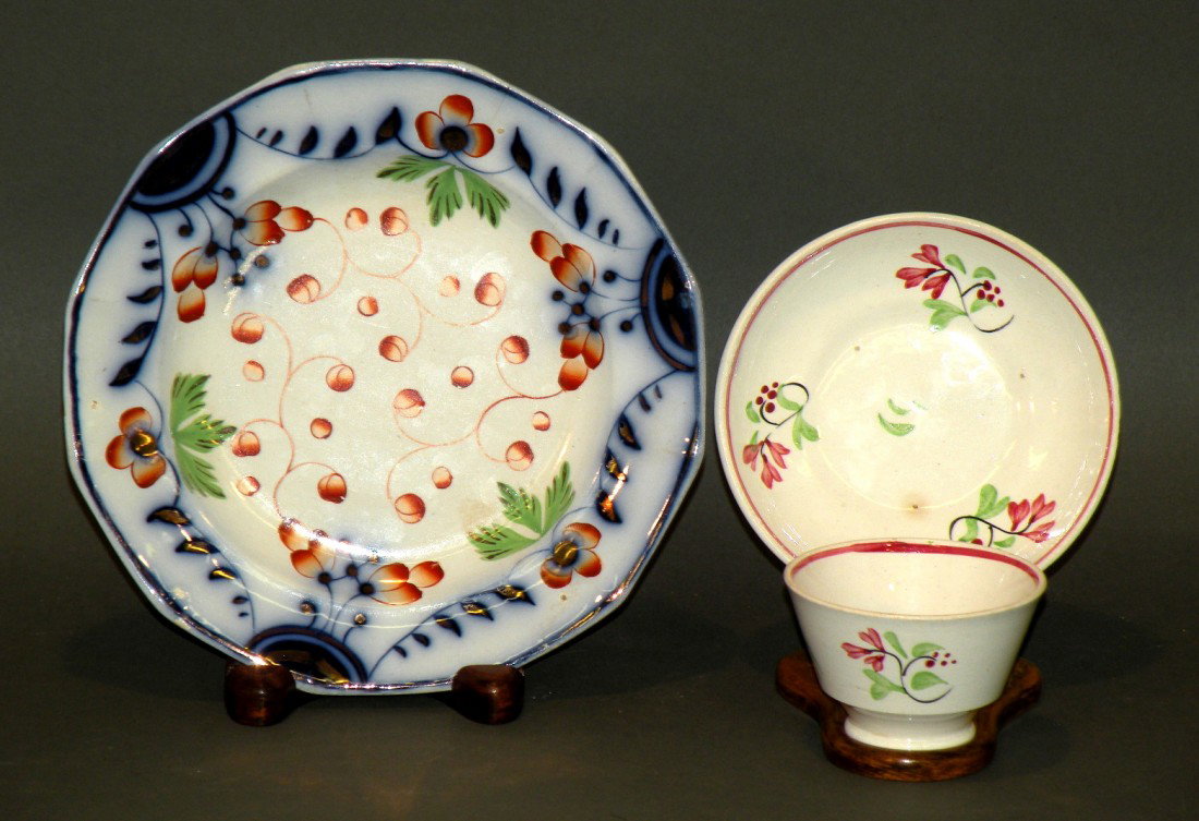 Child's cup & saucer & Gaudy Welsh plate: ca. 1850; pearlware handleless cup 2 7/8"d, 1 7/8"h and saucer 4 5/8"d with simple polychromal floral design in black, green and red; ironstone twelve sided Gaudy Welsh plate in grape variant design a