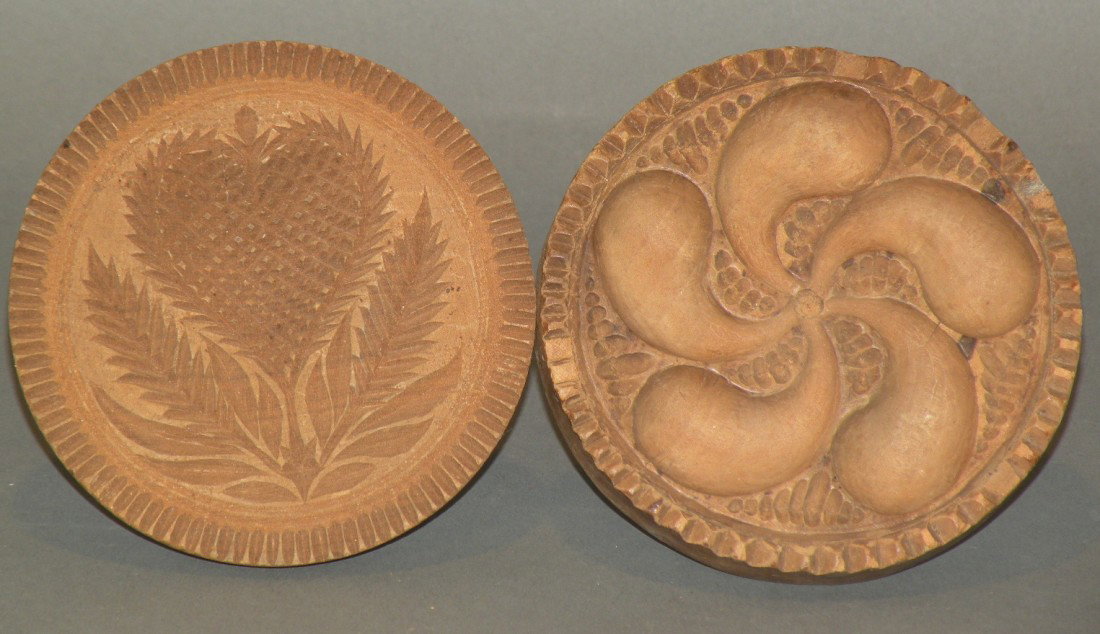 Strawberry & pinwheel design butter prints: ca. 1800-60; deeply carved strawberry with serrated edges, 4 ¼"x 3 1/8"; deeply carved pinwheel design with toothed border, compass star on back and turned applied handle, 4 ½"x 3";