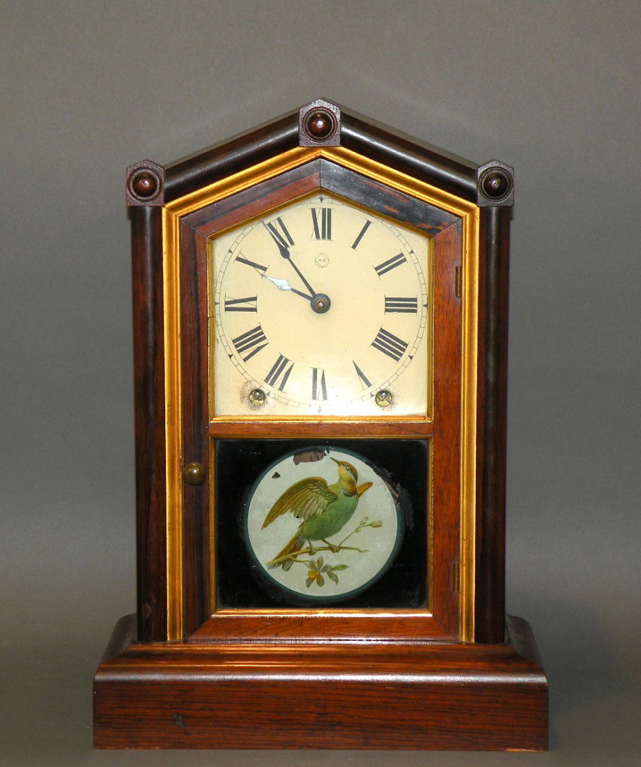 Seth Thomas "Albert" City Series Clock: ca. 1880; 8 day time and strike spring driven pendulum movement in a rosewood case with painted metal dial, silk screened lower glass, and original label on inside case, 16 ½" tall;