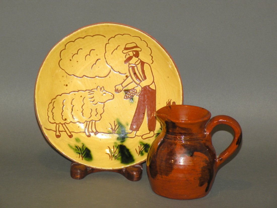 2 pieces of Breininger pottery: ca. 1986-87; sgraffito plate inscribed “A potter and his sheep Dec 9, 1986..”, 7”d; manganese splashed redware creamer incised “LB 87 PA”, 3 ¼”d, 3 ¾”h;
