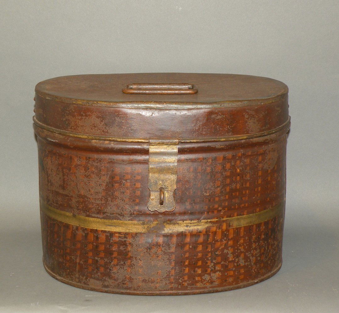 Painted toleware lidded tin: ca. 1830-60; oval canister with hinged lid, original paint decoration with brown dappling and yellow striping, 13 3/8”x 10 5/8”x 10”;