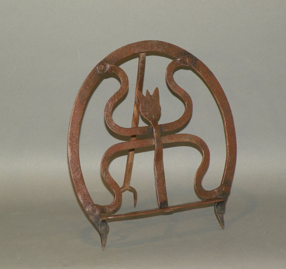 Wrought iron tulip design fire trivet: ca. 1940-60; shield shaped design with twisted support leg, 17 ¼”x 10 7/8”x 8 ¼”;