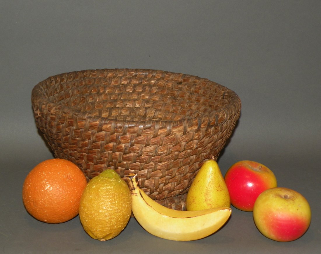 Rye straw basket & stone carved fruit: ca. 1840-1950; pedestal based basket with double coil base, 11 1/8”x 5 ½”; carved stone pear, banana, lemon, orange and two apples, 3 ¼”x 2 1/8”- 5 ¼”x 3”;
