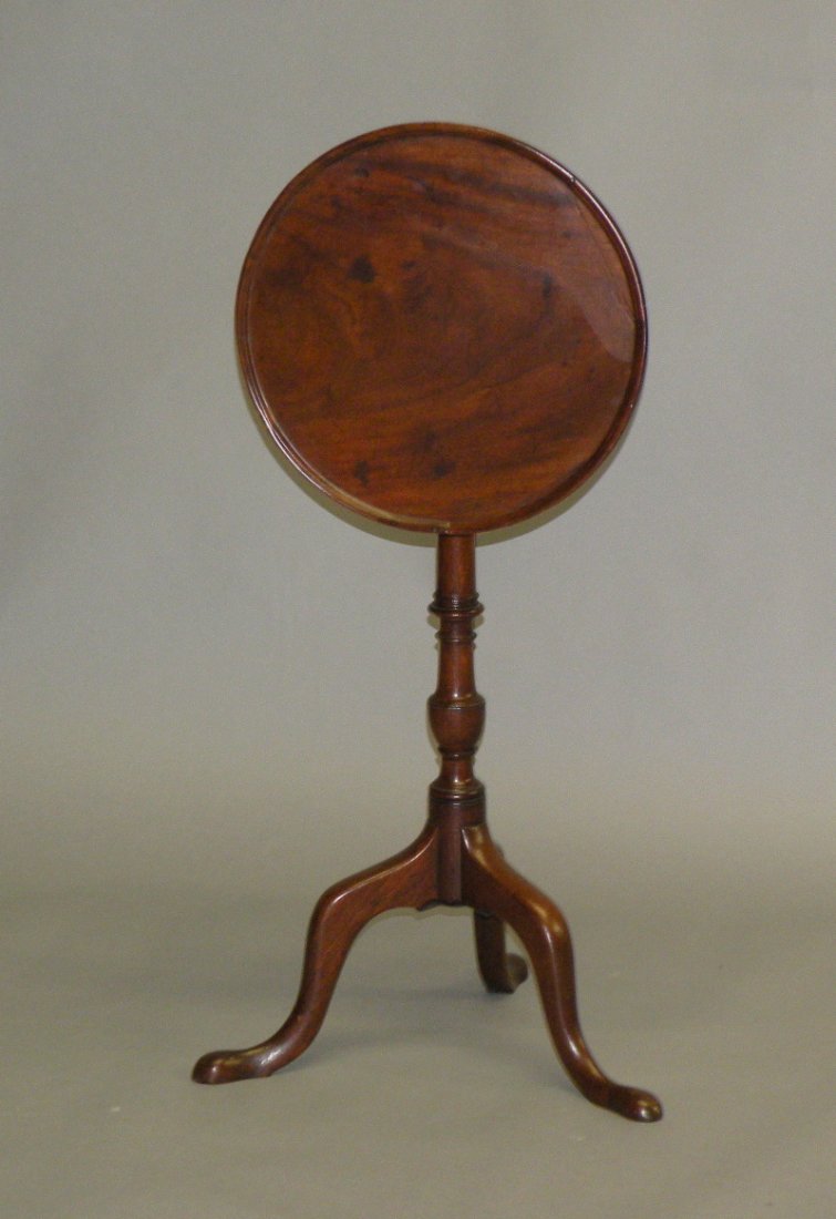 Diminutive mahogany tilt top candle stand: ca. 1770; with nicely turned pedestal resting on tripod base with snake feet, 15”d, 27”h;