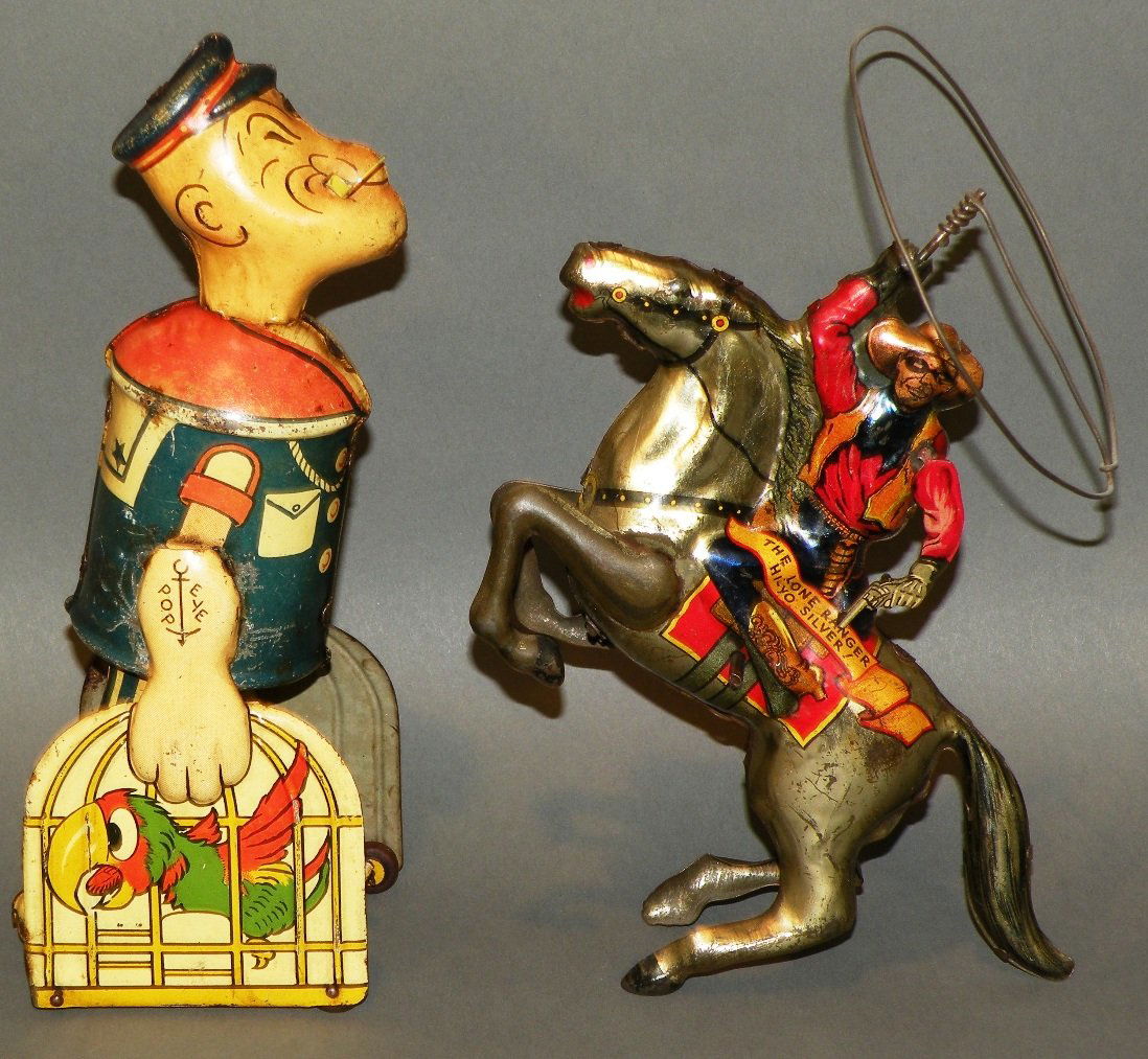 Lone Ranger & Popeye tin wind-up toys: ca. 1930s; Lone Ranger with spinning lasso and moving gun arm on a reared up Silver, 8”; Popeye walks and carries 2 parrot cages, 8”;
