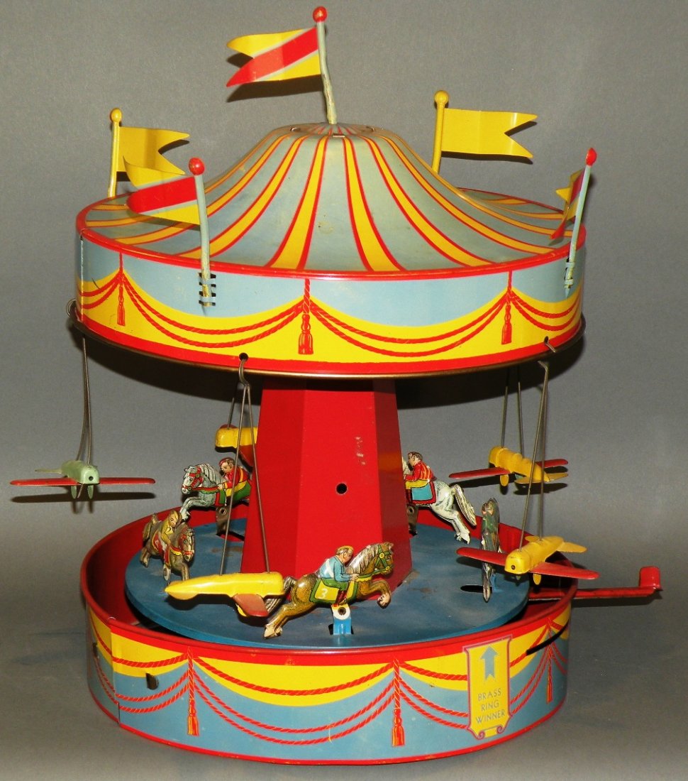 Wolverine merry-go-round wind-up toy: ca. 1930-40; tin litho lever wind musical merry-go-round with five flags and airplanes, 15”;