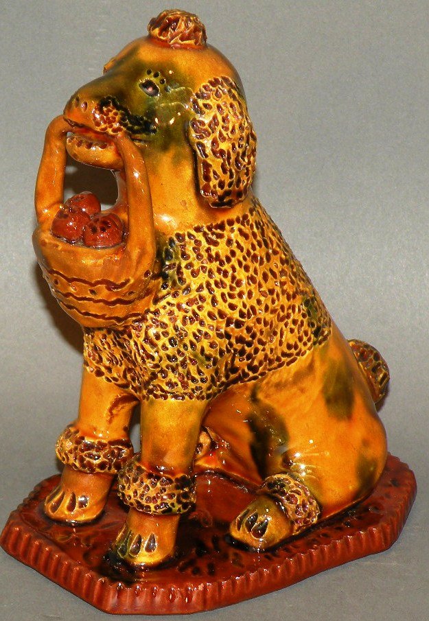 Breininger redware dog: ca. 1989; seated tooled dog on a slab holding a basket of fruit and incised “Breininger Pottery, Robesonia, 1989”; 5 ¾”x 3”x 4 5/8”;