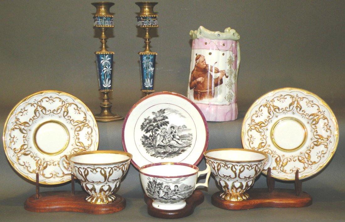 5 pieces of china & pair of candlesticks: ca. 1820-1900; English handled pink lustre cup and saucer with black transfer of woman and two children; central European half liter puzzle jug with colored transfer of friar playing a violin set agai