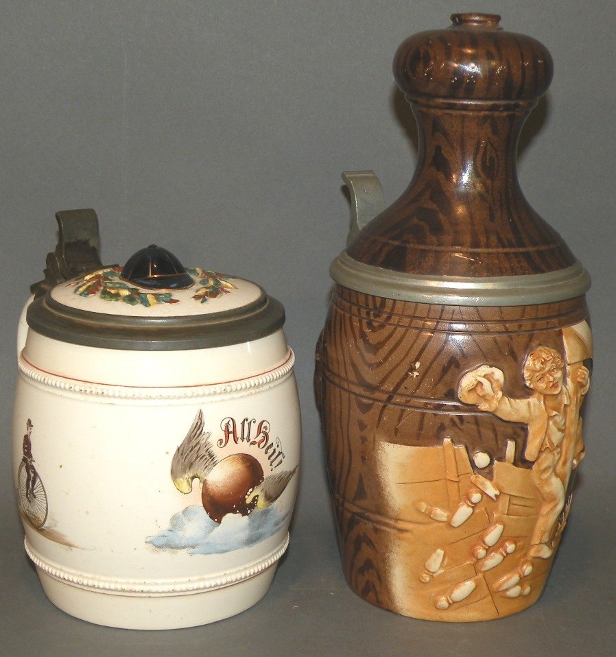 2 German steins: ca. 1900; bowling pin form with relief décor and marked on the base “1134” Germany; Thomasberger and Hermann print under glaze of bicyclists with relief lid; tallest 9”;