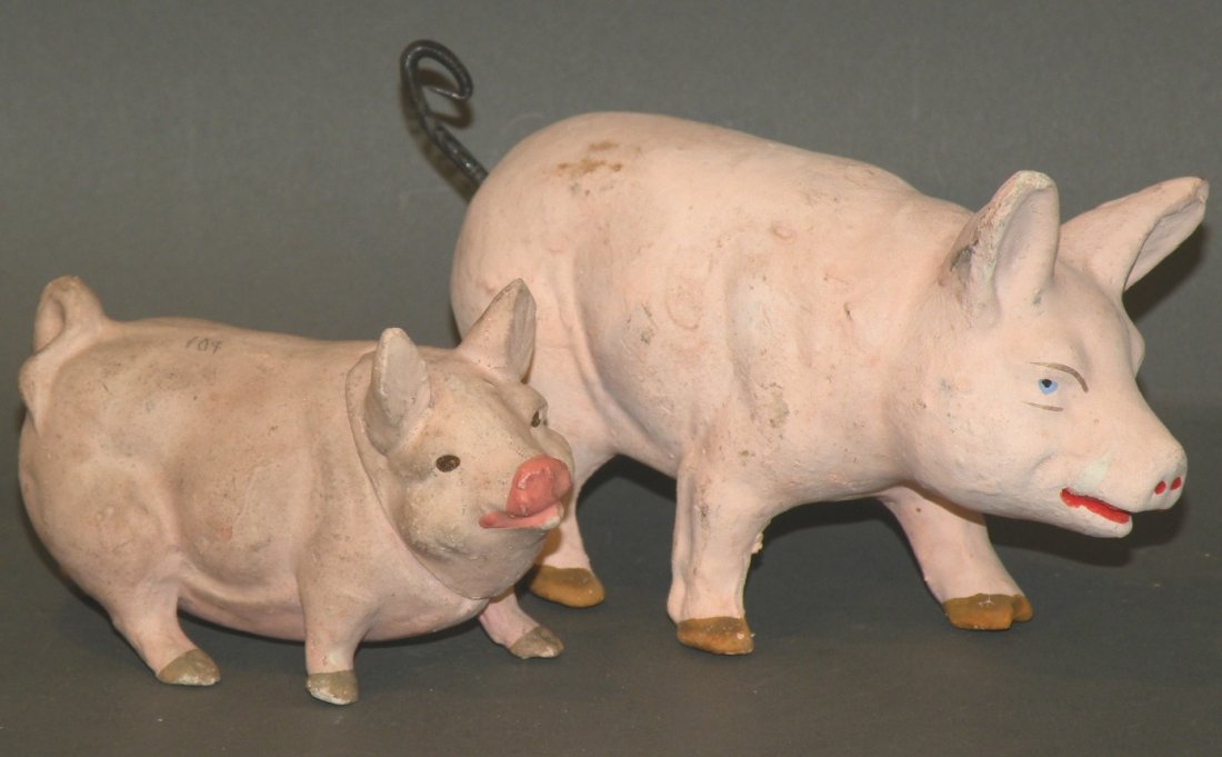 2 German papier mache pigs: ca. 1910; composition pig with spring tail, 6”; composition pig candy container, 4”;