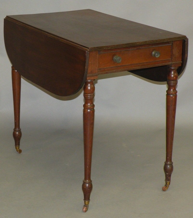 Sheraton Pembroke table: ca. 1810; mahogany with fluted top edges having one drawer with two brass pulls over turned legs supported by brass castors, 33”x 20 ½”x 29”;