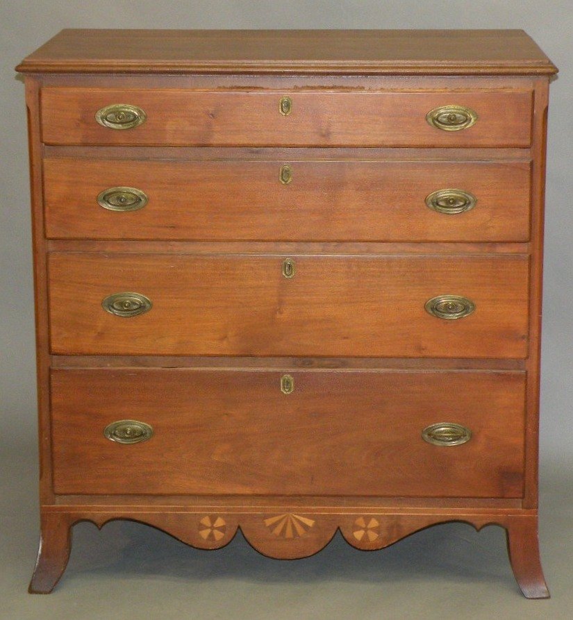 Hepplewhite chest of drawers: ca. 1810; walnut chest of four drawers with stamped brasses, chamfered corners on flaring French feet and a contoured skirt with inlayed decoration, 23”x 43”x 45 ½”;