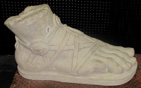 Stone Roman sandal with a thin thong, right. H: 21: Stone Roman sandal with a thin thong, right. H: 21" W: 33" D: 15"