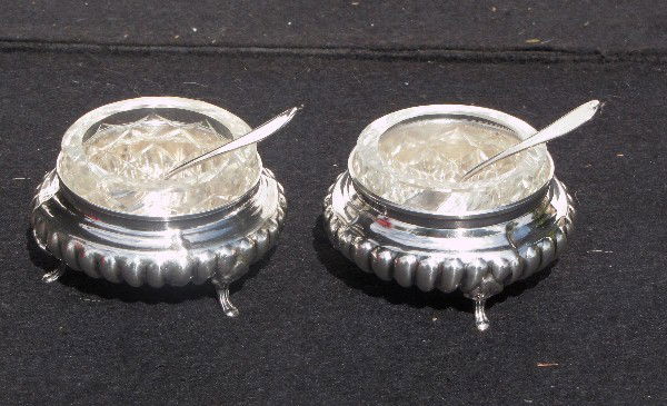 Pair of sterling silver salt cellars and spoons wit: Pair of sterling silver salt cellars and spoons with glass liners, total approx. wt. 8 troy ounces.