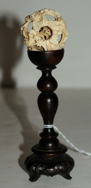 Chinese carved ivory puzzle ball: on a carved hardwood stand. Overall: 5 1/2" Ivory: 1 1/2"