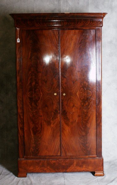 Louis Philippe two door flame mahogany flat top ar: Louis Philippe two door flame mahogany flat top armoire having matched veneerpanels, ogee cornice moulding, doors inset in decorative ogee moulding, rising on blockfeet, circa 1850 . H:74.5" W:34.25" 